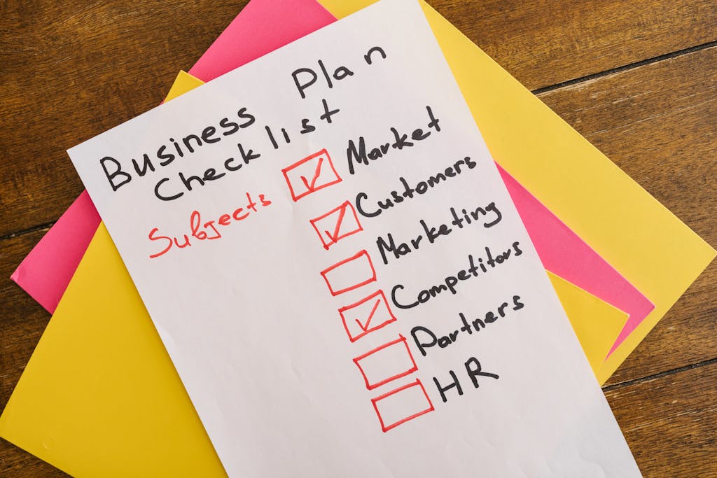 A handwritten business plan checklist on a table with colorful papers indicating importance content marketing